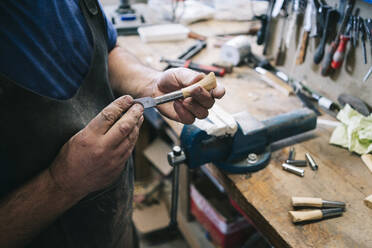 Craftsman making knives in his workshop - DGOF00793