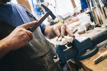 Craftsman working on knive in his workshop - DGOF00795