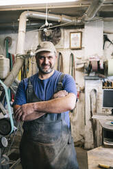 Porträt eines selbstbewussten Messermachers in seiner Werkstatt - DGOF00804