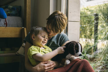 Mutter und kleiner Sohn kuscheln am Fenster - MFF05412