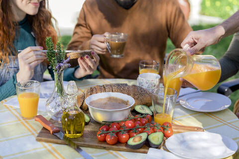 Nahaufnahme von Freunden, die ein gesundes veganes Frühstück im Freien genießen, lizenzfreies Stockfoto