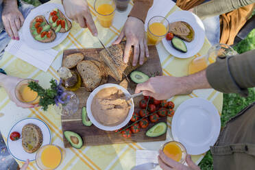 Nahaufnahme von Freunden, die ein gesundes veganes Frühstück im Freien genießen - VSMF00013