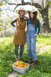 Zwei Frauen mit ihrer Ernte von Bio-Orangen und -Zitronen - VSMF00043