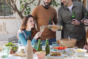 Freunde genießen das Mittagessen auf dem Lande, trinken Wein und Bier - VSMF00046