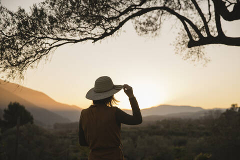 Frau genießt die Aussicht auf den Sonnenuntergang auf dem Land, Orgiva, Andalusien, Spanien, lizenzfreies Stockfoto