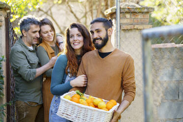 Glückliche Freunde halten einen Korb mit Zitronen und Orangen - VSMF00152