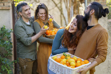Glückliche Freunde halten einen Korb mit Zitronen und Orangen - VSMF00153