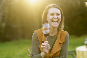 Glückliche Frau trinkt Rotwein auf dem Lande - VSMF00168