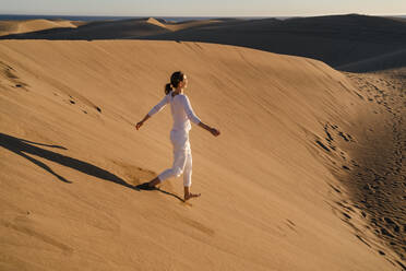 Woman running down sand dune, Gran Canaria, Spain - DIGF09535