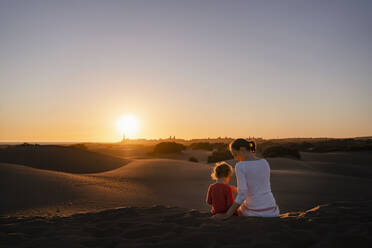 Mutter und Tochter sitzen bei Sonnenuntergang in den Sanddünen, Gran Canaria, Spanien - DIGF09542