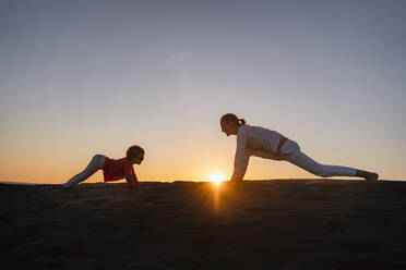 Mutter und Tochter üben Yoga in den Sanddünen bei Sonnenuntergang, Gran Canaria, Spanien - DIGF09545