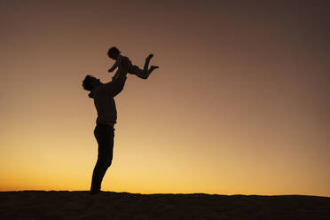 Vater spielt mit Tochter auf Sanddüne bei Sonnenuntergang, Gran Canaria, Spanien - DIGF09556