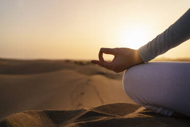 Nahaufnahme einer Frau, die bei Sonnenuntergang in den Sanddünen Yoga übt, Gran Canaria, Spanien - DIGF09607