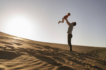 Vater spielt mit Tochter in Sanddüne bei Sonnenuntergang, Gran Canaria, Spanien - DIGF09616