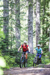 Two female bikers enjoy a trail in Sandy, OR near Mt. Hood. - CAVF78992
