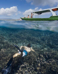 Junger Mann beim Schnorcheln in der Nähe des Bootes im Meer, Unterwasseransicht - CAVF79003