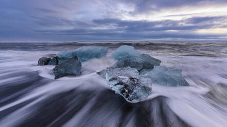 Island, Eisbrocken am Ufer von Jokulsarlon in der Abenddämmerung - TOVF00167