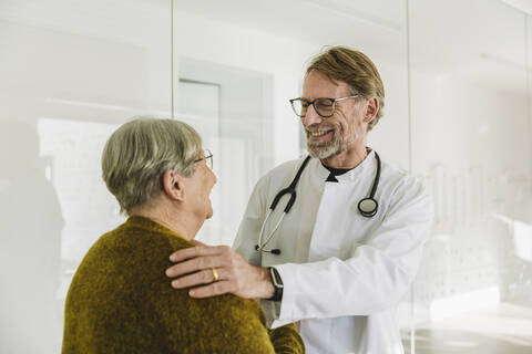 Smiling doctor and senior patient in medical practice stock photo