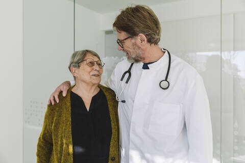 Caring doctor talking to senior patient in medical practice stock photo