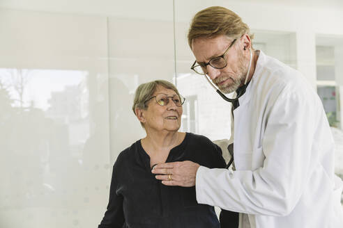 Arzt hört den Herzschlag eines älteren Patienten ab - MFF05431