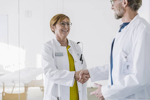 Zwei lächelnde Ärzte beim Händeschütteln, lizenzfreies Stockfoto