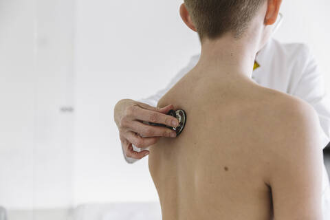 Doctor examining teenage boy with a stethoscope stock photo