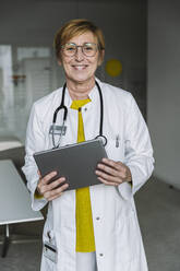 Portrait of smiling doctor holding tablet - MFF05552