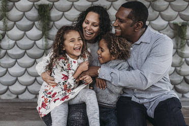 Lifestyle-Bild einer glücklichen Familie, die sich gegenseitig kitzelt und lacht, während - CAVF79017