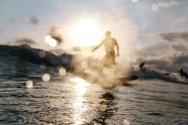 Surfer auf einer Welle bei Sonnenuntergang - CAVF79025