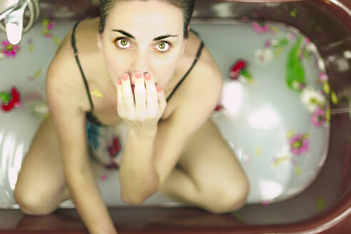 Portrait of woman taking a milk bath with blossoms - ERRF03398