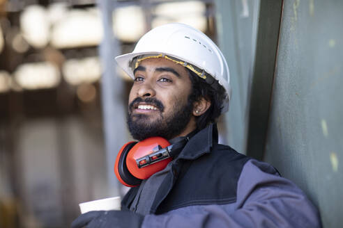 Technician wearing helmet and beard, during break - SGF02598