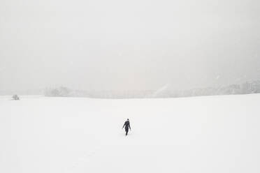 Woman walking alone in snow-covered landscape - WFF00295