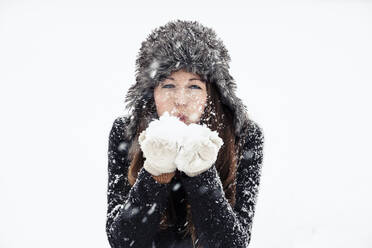 Portrait of young woman blowing snow - WFF00296