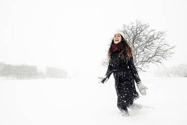 Glückliche junge Frau tanzt in Winterlandschaft - WFF00306