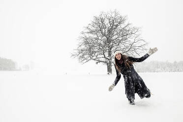 Glückliche junge Frau, die sich in einer Winterlandschaft amüsiert - WFF00309