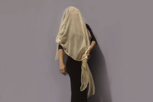 Woman under cloth in front of gray wall - ERRF03415