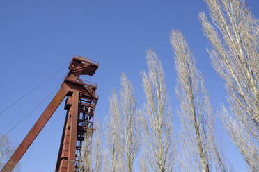 Deutschland, Nordrhein-Westfalen, Kamen, Tiefblick auf einen verlassenen Förderturm bei klarem Himmel - WIF04227