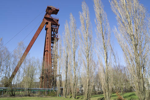 Deutschland, Nordrhein-Westfalen, Kamen, Tiefblick auf einen verlassenen Förderturm bei klarem Himmel - WIF04228