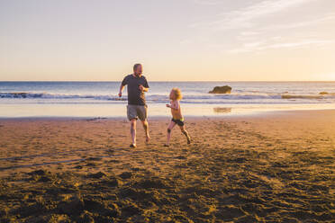 Vater und Sohn spielen und laufen am Strand - IHF00326