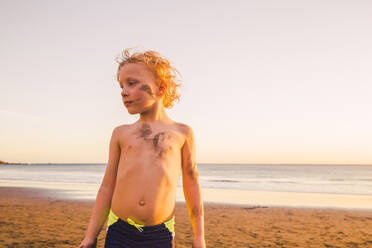 Porträt eines kleinen Jungen am Strand, mit Schlamm im Gesicht - IHF00328