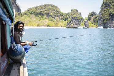 Young native man fishing on a boat trip, Ko Yao Yai, Thailand - FBAF01451