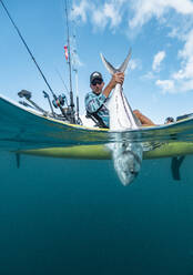 Split Shot von Mann in einem Kajak fängt einen Fisch - AMUF00039