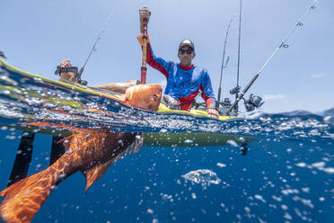 Split shot of man in a kayak catching a fish - AMUF00045