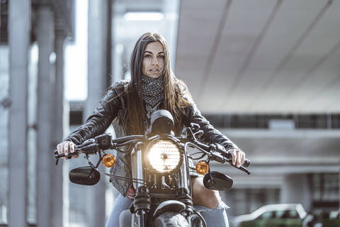 Junge schöne Frau fährt Motorrad in der Stadt, lizenzfreies Stockfoto
