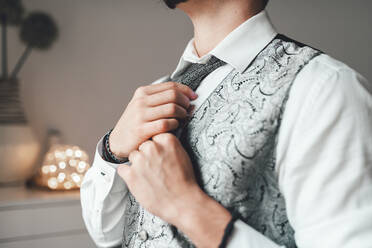 Junger Bräutigam bindet Krawatte für sein Hochzeitsoutfit - AMAF00030