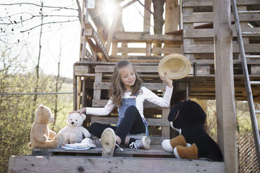 Mädchen spielt mit ihren Teddybären im Baumhaus - HMEF00880