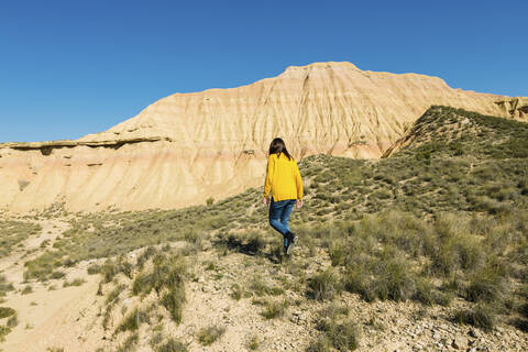 Woman walking in desertic landscape of Bardenas Reales, Arguedas, Navarra, Spain stock photo