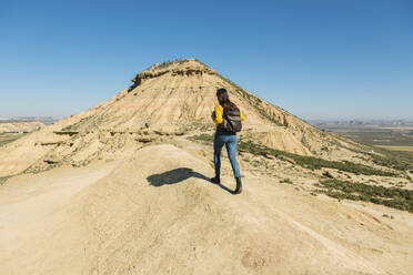 Frau beim Spaziergang in der Wüstenlandschaft von Bardenas Reales, Arguedas, Navarra, Spanien - XLGF00010