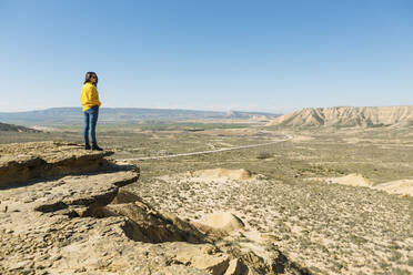 Frau genießt die Aussicht in der Wüstenlandschaft von Bardenas Reales, Arguedas, Navarra, Spanien - XLGF00012