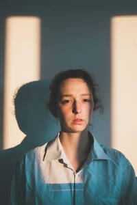 Porträt einer traurigen Frau bei Sonnenaufgang zu Hause - FVSF00095